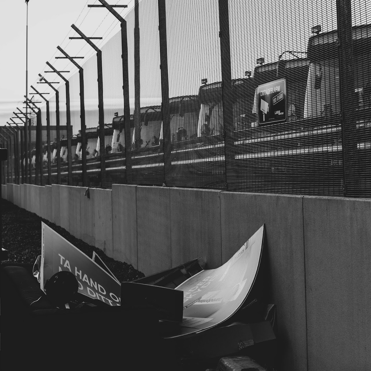 Monochrome fence, roadway, and white tarp folded below