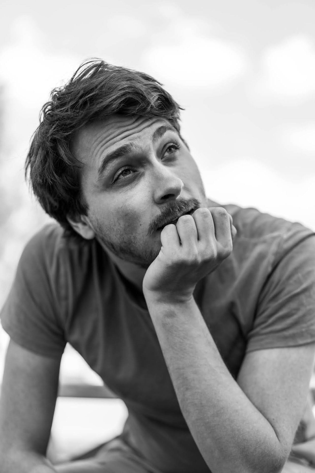 Monochrome man leaning on his hand and looking upward