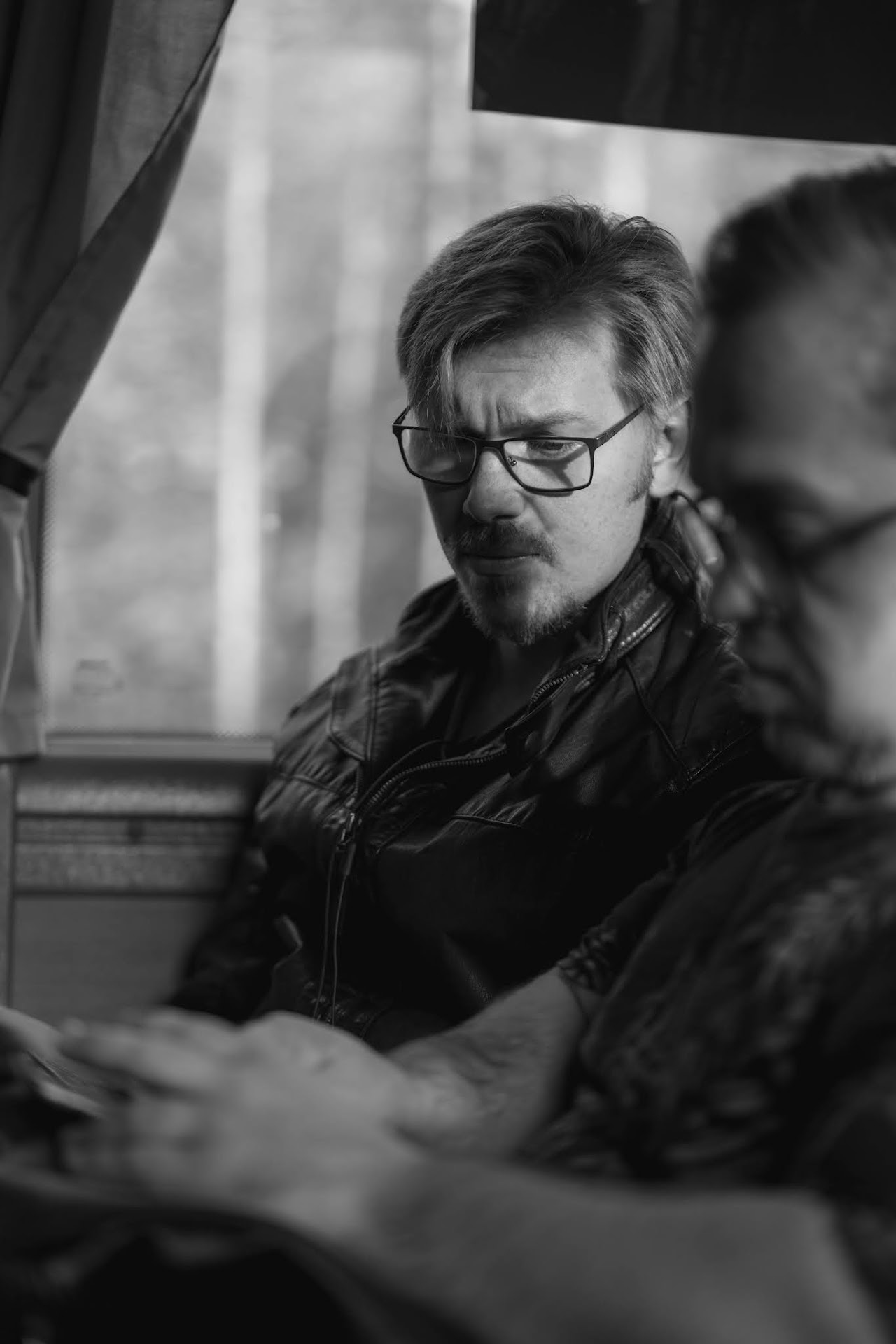 Monochrome man with glasses writing at a table