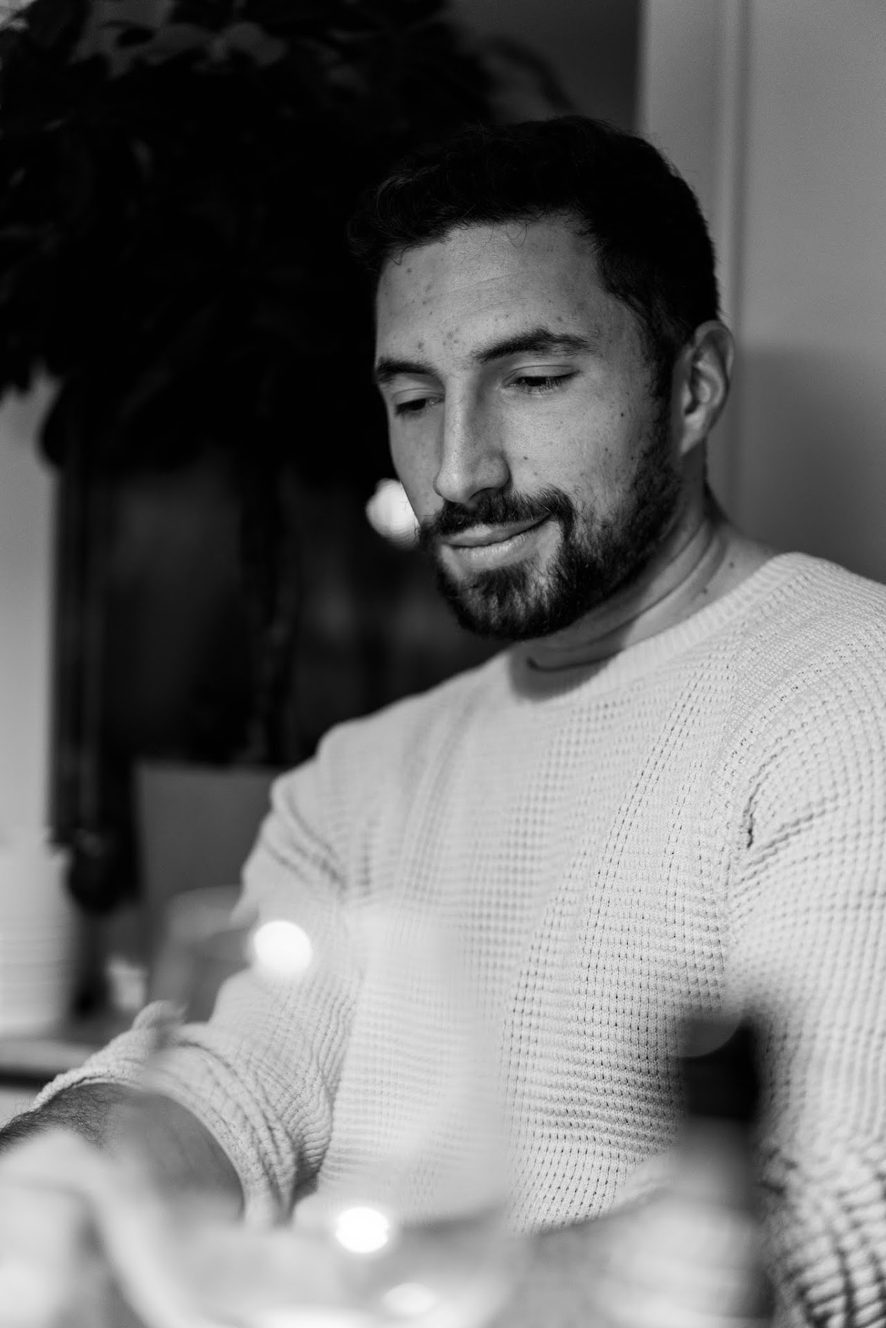 Monochrome smiling man seated at a table in soft light