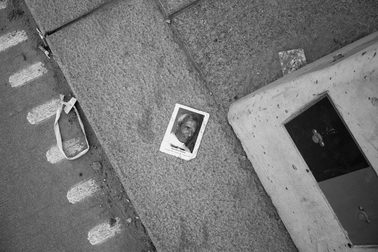 Monochrome pavement detail with a discarded portrait print