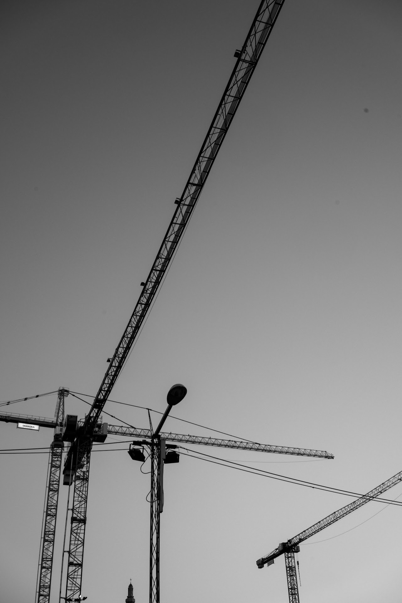 Monochrome Slussen cranes and streetlights against open sky
