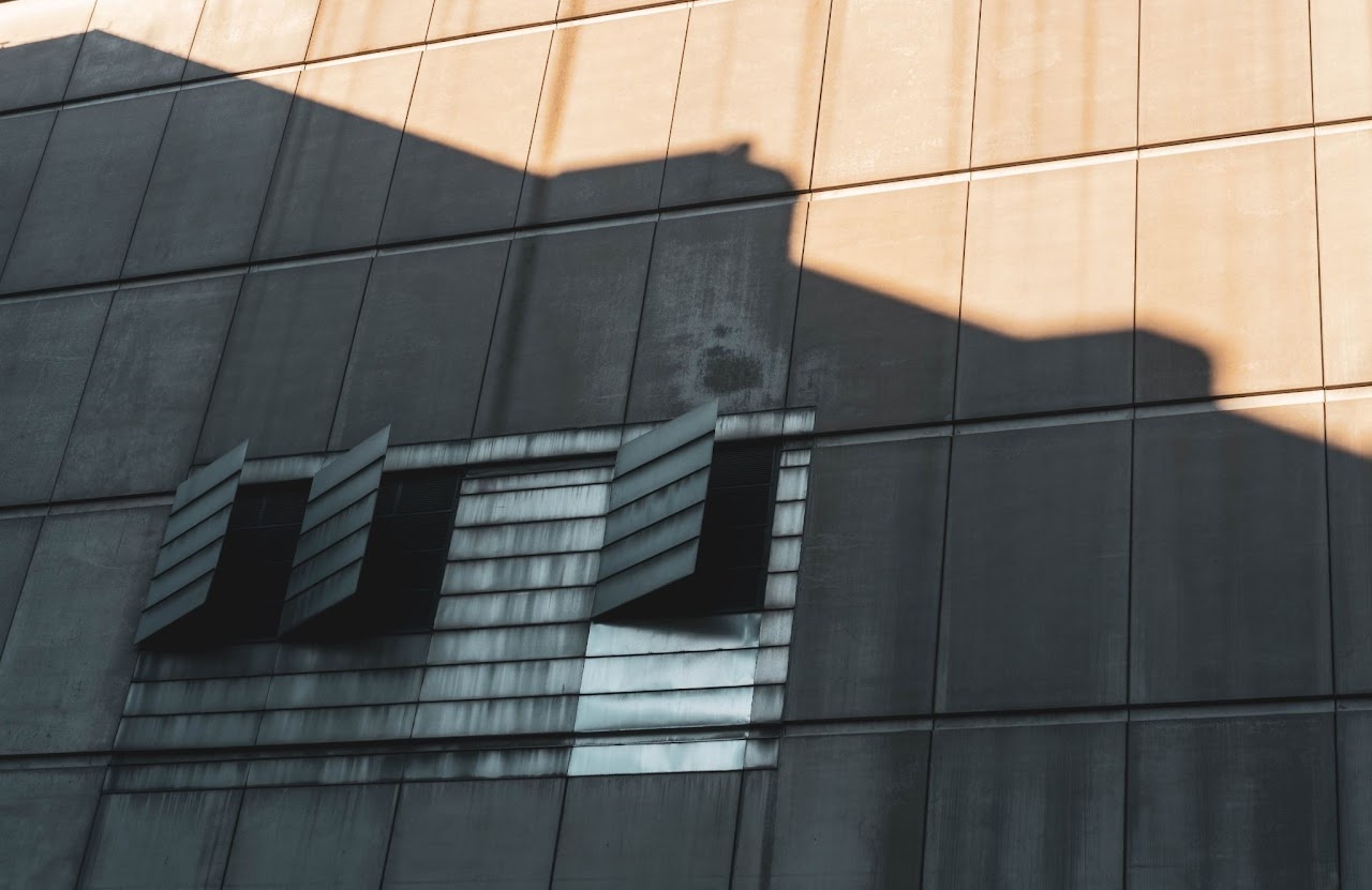 Sunlit wall with hard geometric shadow and small windows