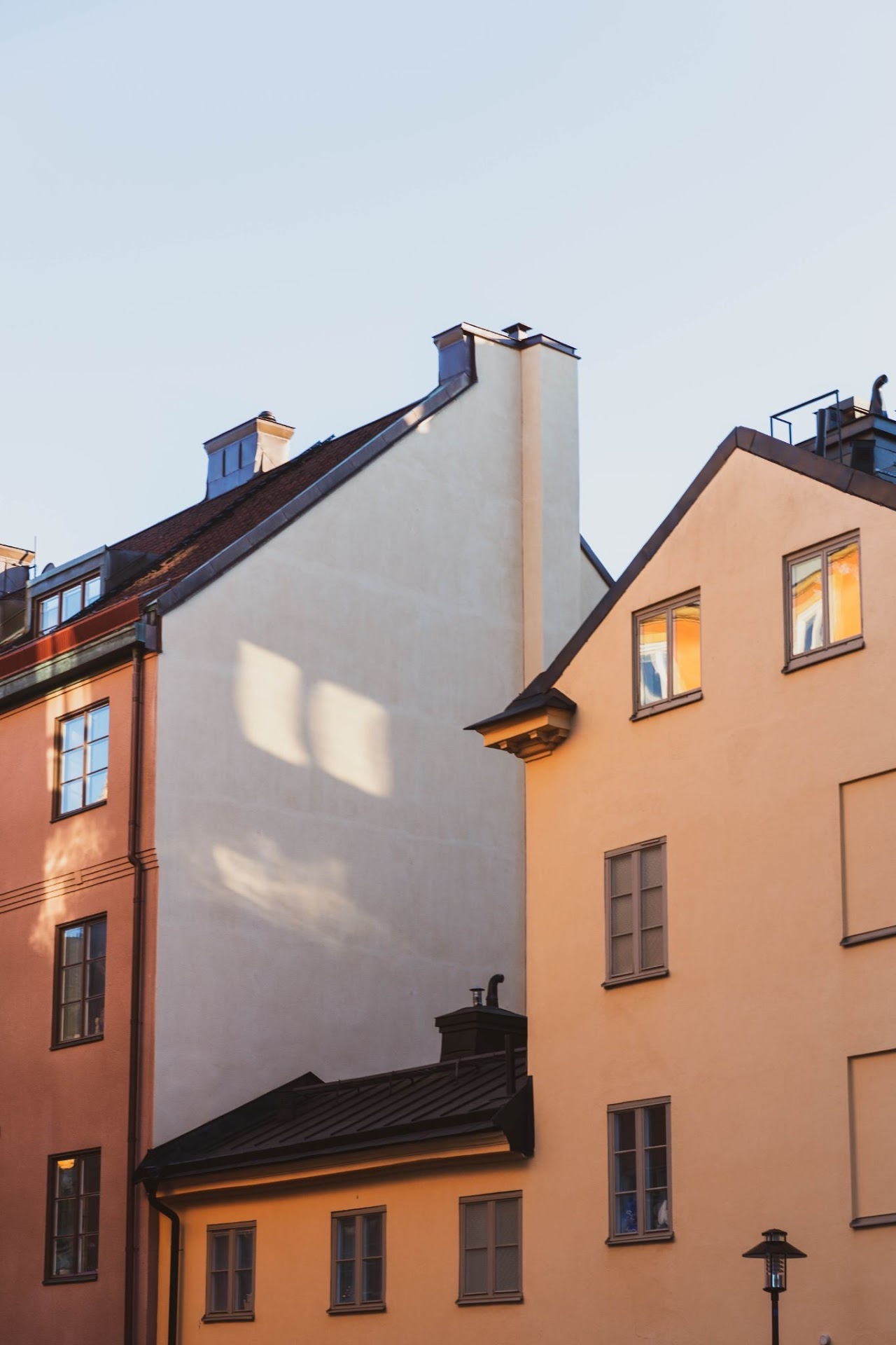 Pastel old facades catching warm sunlight and roof shadows